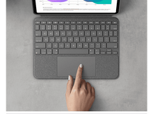 Charger l&#39;image dans la galerie, Main utilisant un pavé tactile sur un clavier, sur une surface grise, vue de dessus.
