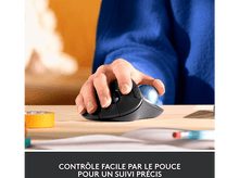 Charger l'image dans la galerie, Une main utilise une souris trackball ergonomique noire et bleue sur un bureau en bois.
