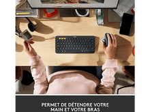 Charger l'image dans la galerie, Les mains tiennent un clavier et une souris sur un bureau en bois.
