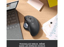 Charger l'image dans la galerie, La main d'une personne repose sur une souris trackball grise. Un ordinateur portable et des documents sur le bureau.
