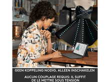 Charger l&#39;image dans la galerie, Femme dessinant sur une tablette, un mannequin avec une robe lumineuse en arrière-plan. Outils visibles.
