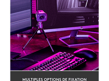 Charger l&#39;image dans la galerie, Une webcam sur un trépied, avec un clavier et un moniteur dans une pièce éclairée en violet.
