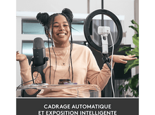 Charger l&#39;image dans la galerie, Une femme sourit en enregistrant avec un micro, une lumière annulaire et une table transparente.
