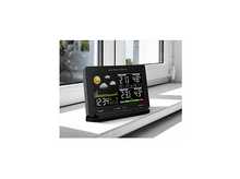 Charger l&#39;image dans la galerie, Une station météo numérique noire sur un rebord de fenêtre. Affiche l&#39;heure, la date et les informations météorologiques.
