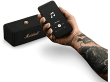 Charger l&#39;image dans la galerie, Haut-parleur Marshall noir et un téléphone affichant des commandes musicales. Fond blanc.
