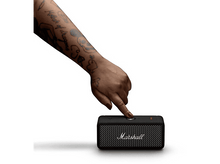 Charger l&#39;image dans la galerie, Une main tatouée appuie sur un bouton d&#39;une enceinte Marshall noire sur fond blanc.
