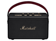 Un haut-parleur Marshall noir avec une poignée rouge. Il a des boutons dorés sur le dessus et la marque est visible.