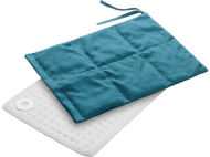 Un coussin chauffant turquoise sur un coussin blanc. Les deux sont matelassés.