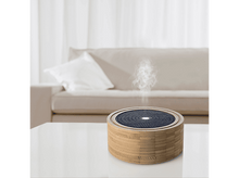 Charger l&#39;image dans la galerie, Un diffuseur d&#39;arômes sur une table blanche. Il a une base en bois et un dessus perforé bleu foncé.
