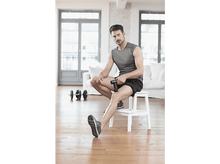 Charger l'image dans la galerie, Un homme assis sur un tabouret, tenant un pistolet de massage.
