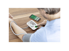 Charger l&#39;image dans la galerie, Homme utilisant un tensiomètre. Téléphone affichant des données à côté du moniteur. Table en bois.
