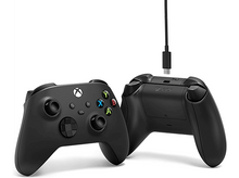 Charger l&#39;image dans la galerie, Manettes Xbox noires, avant et arrière, connectées à un câble USB-C, sur fond blanc.
