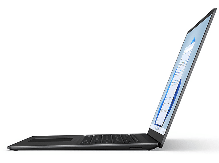 Un ordinateur portable argenté est légèrement ouvert. L'écran affiche une interface Windows. Le clavier et le pavé tactile sont visibles.