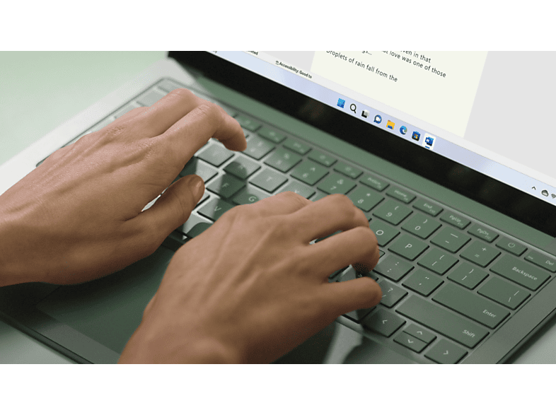 Mains tapant sur un clavier d'ordinateur portable gris ; un document est ouvert à l'écran.