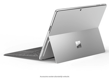 Charger l&#39;image dans la galerie, Un ordinateur portable argenté sur une table, ouvert, avec un clavier et un logo visible.
