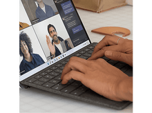 Charger l&#39;image dans la galerie, Mains tapant sur le clavier d&#39;un ordinateur portable, appel vidéo à l&#39;écran avec plusieurs personnes.
