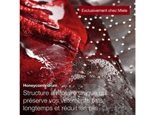 Charger l&#39;image dans la galerie, Tissu rouge dans une machine à laver, gros plan. Détail du tambour alvéolé.
