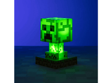 Charger l&#39;image dans la galerie, Une lampe Creeper verte de Minecraft brillant sur une base carrée contre un fond bleu.
