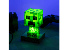Charger l&#39;image dans la galerie, Une lampe Creeper Minecraft verte brillant sur un support contre un fond bleu.
