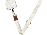 Coque de téléphone crème avec imprimé floral, reliée à une sangle crème avec accessoires dorés.