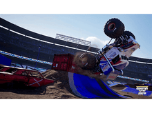 Charger l&#39;image dans la galerie, Un monster truck en l&#39;air, dans un stade, avec une voiture rouge au sol.
