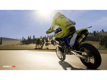 Charger l&#39;image dans la galerie, Une moto de course sur une piste. Le pilote porte une combinaison jaune et noire. Le soleil brille.
