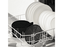 Charger l&#39;image dans la galerie, Vaisselle dans un lave-vaisselle, comprenant des assiettes et un récipient noir avec un couvercle perforé.
