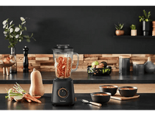 Charger l&#39;image dans la galerie, Mixeur avec légumes à l&#39;intérieur, à côté de bols de soupe sur une surface noire.
