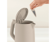 Charger l&#39;image dans la galerie, La main d&#39;une personne place un filtre dans une bouilloire électrique blanche.
