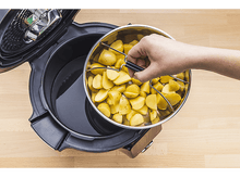 Charger l&#39;image dans la galerie, Une main soulevant un panier en acier de pommes de terre d&#39;un pot ouvert rempli d&#39;eau. Le pot est noir.
