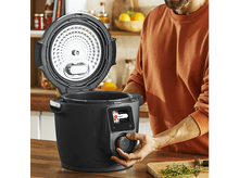 Charger l&#39;image dans la galerie, Homme utilisant une cuisinière intelligente noire avec couvercle ouvert sur un comptoir en bois.
