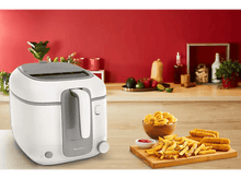Charger l&#39;image dans la galerie, Friteuse blanche et grise, avec aliments et ingrédients sur table en bois et fond rouge.
