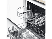 Charger l&#39;image dans la galerie, Intérieur du lave-vaisselle avec deux paniers. Un gobelet doseur transparent et un panier à ustensiles sont visibles.
