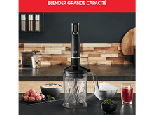 Charger l&#39;image dans la galerie, Mixeur avec un corps noir et un récipient transparent, et divers aliments sur un comptoir.
