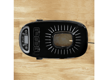 Charger l&#39;image dans la galerie, Machine à pain noire sur une table en bois, pain à l&#39;intérieur.
