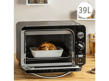 Charger l&#39;image dans la galerie, Four Moulinex noir avec poulet rôti à l&#39;intérieur. Porte ouverte. Plat de cuisson blanc.
