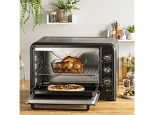 Charger l&#39;image dans la galerie, Un couple prenant un selfie avec un paysage vert en arrière-plan.
