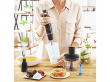 Charger l&#39;image dans la galerie, Une personne utilise un mixeur plongeant noir pour mélanger des ingrédients dans un récipient transparent.
