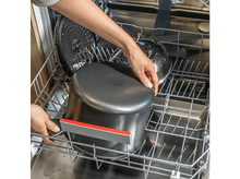 Charger l&#39;image dans la galerie, Personne mettant une casserole dans un lave-vaisselle. Casserole argentée et noire.
