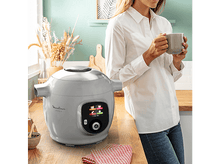 Charger l&#39;image dans la galerie, Moulinex Cookeo gris. Femme en arrière-plan, scène de cuisine.

