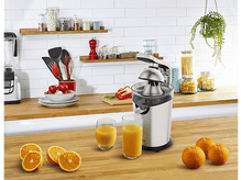 Charger l&#39;image dans la galerie, Un presse-agrumes avec des oranges et deux verres de jus.
