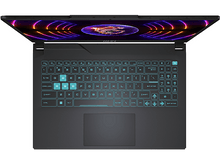 Charger l&#39;image dans la galerie, Vue de dessus d&#39;un ordinateur portable noir avec un écran partiellement ouvert affichant un design abstrait coloré. Le clavier est éclairé en bleu.
