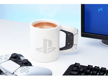 Charger l&#39;image dans la galerie, Mug PS5 blanc avec logo PS et anse en forme de manette, boisson chaude dedans.
