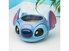 Charger l&#39;image dans la galerie, Un mug Stitch bleu avec vapeur de café, sur une surface blanche avec feuillage en arrière-plan.
