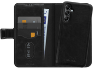 Étui de téléphone noir avec portefeuille, cartes de crédit et argent. Un téléphone noir à droite.