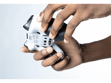 Charger l&#39;image dans la galerie, Mains tenant une manette blanche et noire, enlevant le côté. Arrière de la manette visible.
