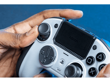 Charger l&#39;image dans la galerie, La main d&#39;une personne tenant une manette de jeu blanche et noire avec des boutons.
