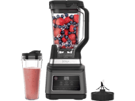 Blender Ninja avec fruits et glace, un verre à smoothie et une lame.