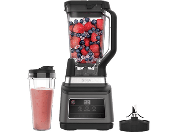 Blender Ninja avec fruits et glace, un verre à smoothie et une lame.