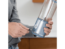 Charger l&#39;image dans la galerie, Une personne branchant un câble USB dans un mixeur.
